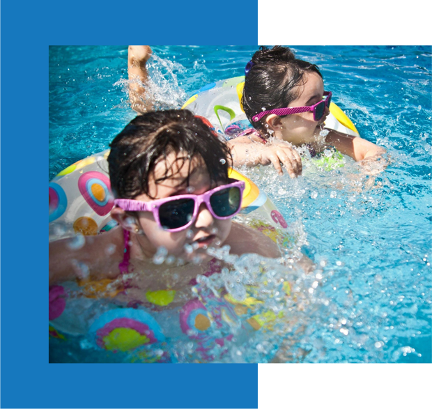 Two children swimming in a pool with floats.